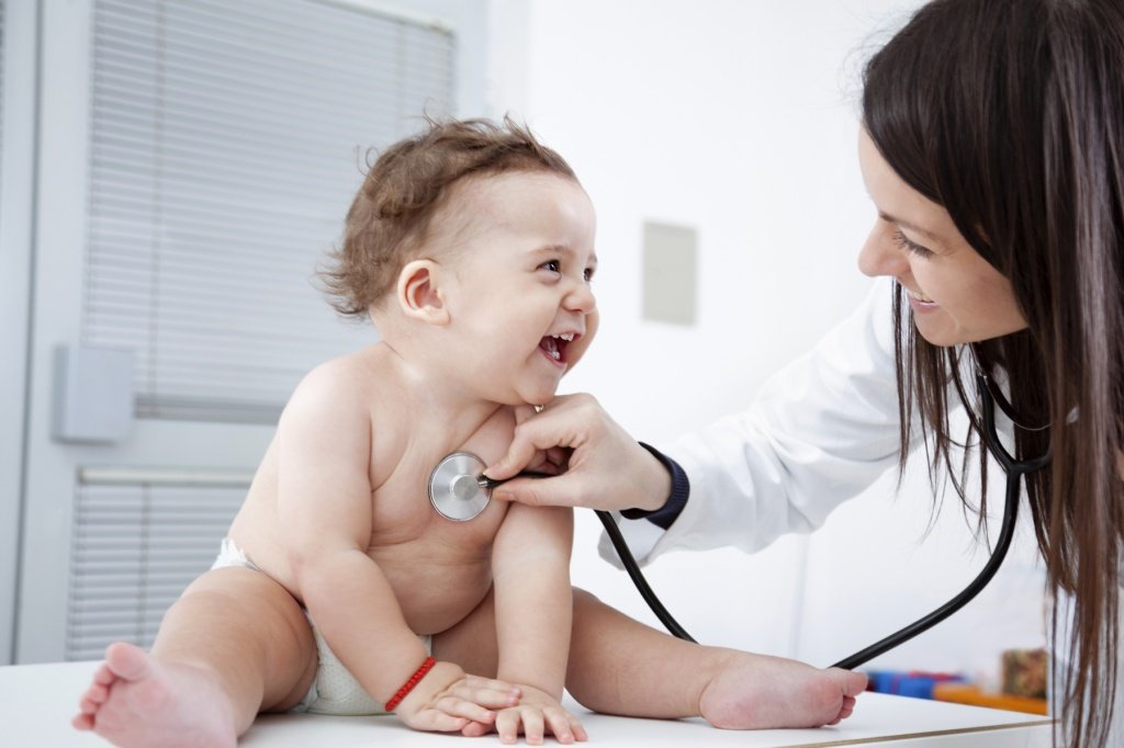 Doctor checking up baby with stethoscope.