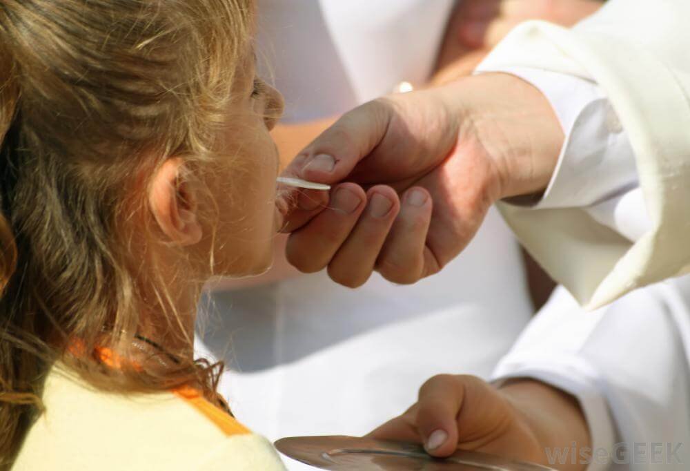 priest-giving-communion-to-a-young-girl